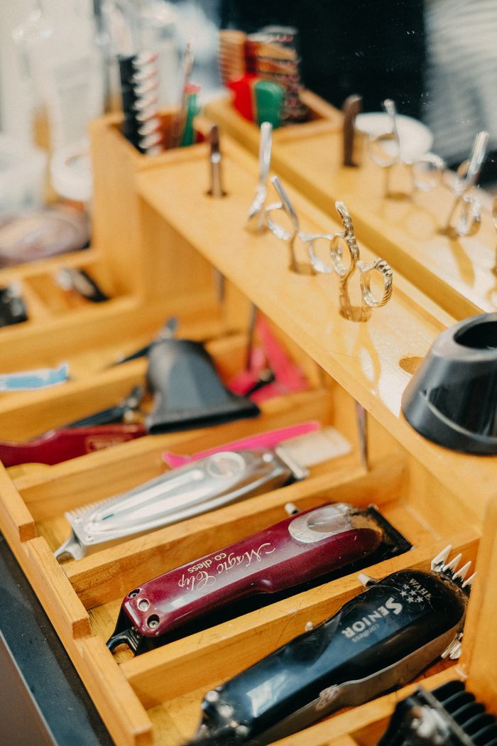 A neatly organized barbershop tray showcasing scissors, combs, and hair trimmers.