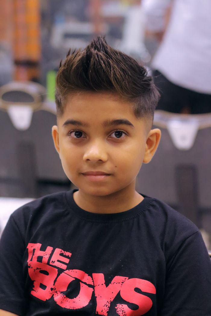 A young boy with a trendy spiky hairstyle wearing a graphic T-shirt.